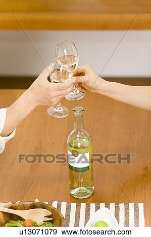 Stock Photo - Hands Toasting with Glasses of Wine, High Angle View, Close Up. Fotosearch