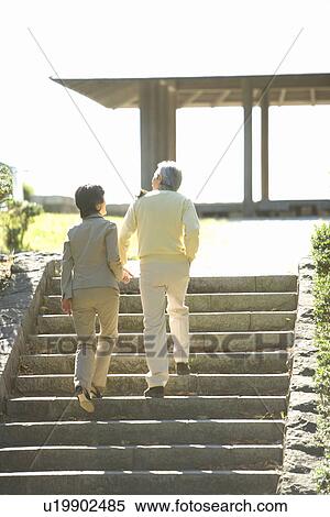 Stock Photography - A Mature Couple Going Up the Stairs, Rear View, Full Length, Low Angle View. Fotosearch