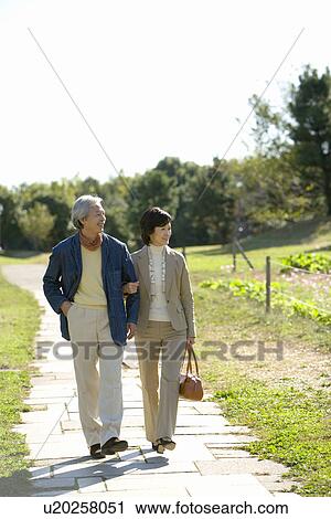A Mature Couple Walking Arm in Arm in a Park, Front View, Full Length View Large Photo Image Stock Image - A Mature Couple Walking Arm in Arm in a Park, Front View, Full Length. Fotosearch