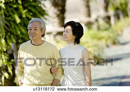 A Mature Couple Walking Arm in Arm, Front View, Waist Up, Differential Focus View Large Photo Image Stock Image - A Mature Couple Walking Arm in Arm, Front View, Waist Up, Differential Focus. Fotosearch
