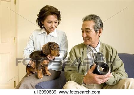 Stock Photo - A Senior Adult Couple at a Sofa, Front View, Side View. Fotosearch