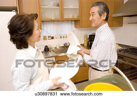 A Senior Adult Couple Cleaning Dishes Together, Side View View Large Photo Image Stock Image - A Senior Adult Couple Cleaning Dishes Together, Side View. Fotosearch