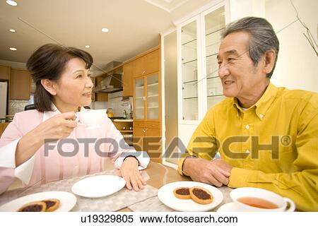 Stock Photography - A Senior Adult Couple Having a Tea Break Together, Front View, Side View. Fotosearch