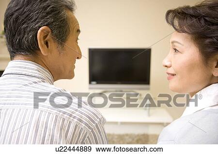A Senior Adult Couple Looking at Each Other in a Living Room with a Television, Rear View, Side View, Differential Focus View Large Photo Image Stock Photo - A Senior Adult Couple Looking at Each Other in a Living Room with a Television, Rear View, Side View, Differential Focus. Fotosearch