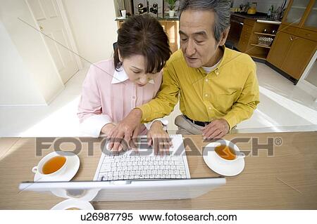 Stock Photography - A Senior Adult Couple Using a Laptop Computer Together, High Angle View. Fotosearch