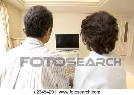 A Senior Adult Couple Watching a Television in a Living Room, Rear View View Large Photo Image Stock Image - A Senior Adult Couple Watching a Television in a Living Room, Rear View. Fotosearch
