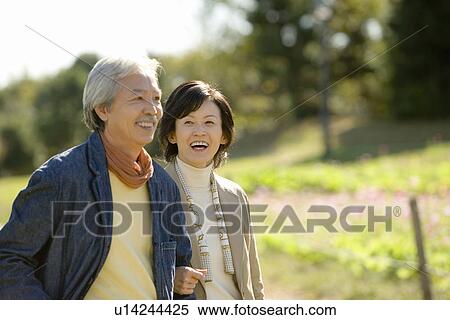 Stock Photography - A Smiling Mature Couple in a Park, Front View, Waist Up. Fotosearch