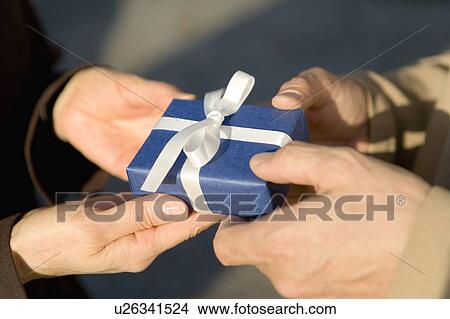 Picture - Closed Up Image of Hands Giving a Present, High Angle View. Fotosearch