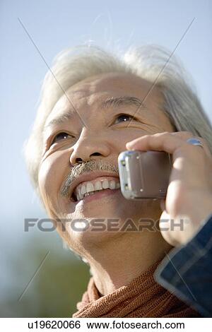 Portrait of a Mature, Smiling Man Talking on a Cellular Phone, Low Angle View, Differential Focus, Close Up View Large Photo Image Stock Photograph - Portrait of a Mature, Smiling Man Talking on a Cellular Phone, Low Angle View, Differential Focus, Close Up . Fotosearch
