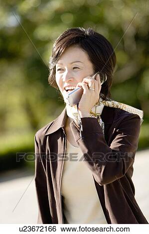 Portrait of a Mature, Smiling Woman Talking on a Cellular Phone, Front View, Differential Focus, Waist Up View Large Photo Image Stock Photograph - Portrait of a Mature, Smiling Woman Talking on a Cellular Phone, Front View, Differential Focus, Waist Up . Fotosearch