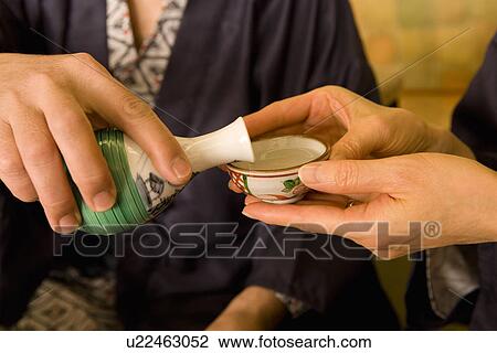 Close-up Image of a Mature Adult Pouring to the Other, High Angle View View Large Photo Image Stock Image - Close-up Image of a Mature Adult Pouring to the Other, High Angle View. Fotosearch