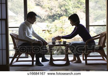 Stock Photo - Mature Adult Couple Drinking Tea at the Japanese-style Hotel, Full Length, Side View. Fotosearch