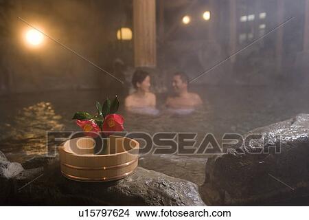 Mature Adult Couple Soaking in a Hot Spring Together and Camellias in the Foreground, Side View, Head and Shoulder, Differential Focus View Large Photo Image Picture - Mature Adult Couple Soaking in a Hot Spring Together and Camellias in the Foreground, Side View, Head and Shoulder, Differential Focus. Fotosearch