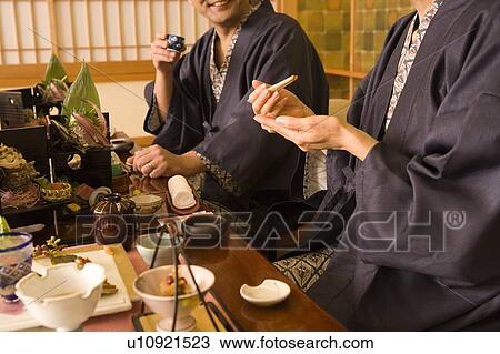Stock Image - Mature Adults in Yukata Having Dinner at a Japanese-style Hotel, Side View, . Fotosearch