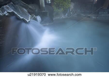 Stock Image - Outside Hot Spring Bath and Hot Spring Splashing, High Angle View, Long Exposure. Fotosearch