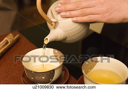 Stock Image - A Woman Serving Japanese Green Tea, High Angle View, Close Up. Fotosearch