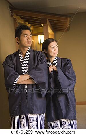 Stock Photo - Cuddling Mid Adult Couple in Yukata, Looking Up, Front View. Fotosearch