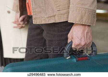 Mid Adult Couple Holding Their Hands, Green Suite Case Held by Man's Hand, Close Up, Differential Focus View Large Photo Image Stock Image - Mid Adult Couple Holding Their Hands, Green Suite Case Held by Man's Hand, Close Up, Differential Focus. Fotosearch
