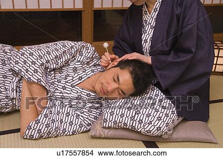 Picture - Mid Adult Couple in Yukata, Man having His ears cleaned on Woman's lap, Front View. Fotosearch