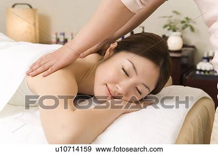 Stock Photo - One woman having massage, side view, Japan. Fotosearch
