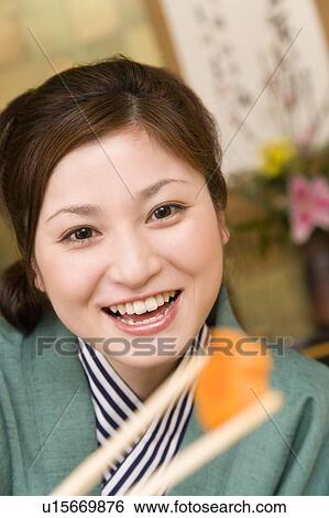 Portrait of a woman holding up chopsticks, front view, close up, differential focus, Japan View Large Photo Image Stock Photograph - Portrait of a woman holding up chopsticks, front view, close up, differential focus, Japan. Fotosearch