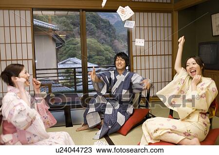 Three young people in Yukata playing cards at a Japanese inn, front view, side view, blurred motion, Japan View Large Photo Image Stock Image - Three young people in Yukata playing cards at a Japanese inn, front view, side view, blurred motion, Japan. Fotosearch