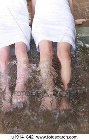 Stock Image - Two women in a hot tub, high angle view, Japan. Fotosearch