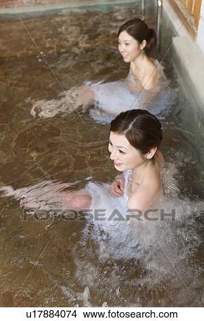 Two women in a hot tub, looking away, high angle view, Japan View Large Photo Image Picture - Two women in a hot tub, looking away, high angle view, Japan. Fotosearch