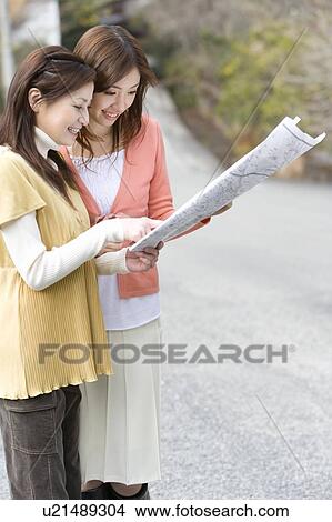 Two women looking at a map on the road, front view, side view, Japan View Large Photo Image Picture - Two women looking at a map on the road, front view, side view, Japan. Fotosearch
