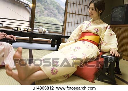 Stock Image - Two young women in Yukata relaxing in the room, front view, side view, Japan. Fotosearch