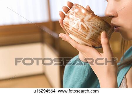 Woman drinking Japanese tea, side view, close up, differential focus, Japan View Large Photo Image Picture - Woman drinking Japanese tea, side view, close up, differential focus, Japan. Fotosearch