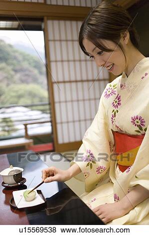 Stock Photo - Woman in Yukata having shi in the room, side view, Japan. Fotosearch