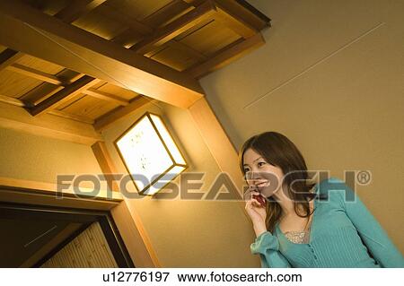 Woman using a mobile phone in a Japanese inn, low angle view, Japan View Large Photo Image Stock Photo - Woman using a mobile phone in a Japanese inn, low angle view, Japan. Fotosearch