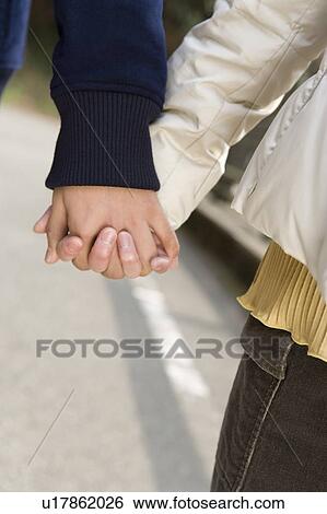 Stock Photograph - Young couple holding their hands, front view, close up, Japan. Fotosearch