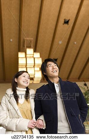 Stock Photography - Young couple smiling in a Japanese inn, low angle view, Japan. Fotosearch