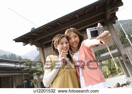 Young women taking a picture of themselves, front view, Japan View Large Photo Image Stock Image - Young women taking a picture of themselves, front view, Japan. Fotosearch