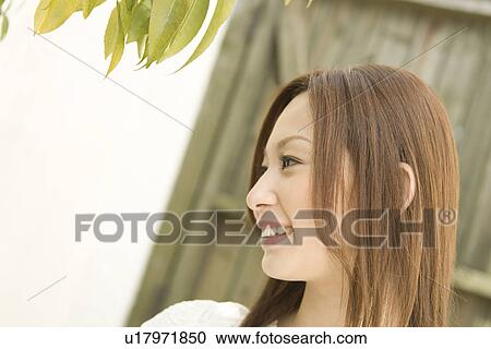 Stock Image - A smiling woman, side view, waist up. Fotosearch