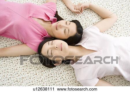 Portrait of Two Young Twin Sisters Lying on Back, Smiling, High Angle View View Large Photo Image Stock Image - Portrait of Two Young Twin Sisters Lying on Back, Smiling, High Angle View. Fotosearch