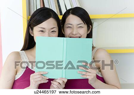 Portrait of Two Young Twin Sisters Reading a Book, Smiling, Front View View Large Photo Image Stock Photo - Portrait of Two Young Twin Sisters Reading a Book, Smiling, Front View. Fotosearch