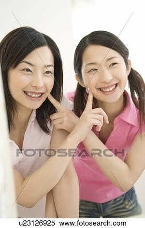 Portrait of Two Young Twin Sisters, Smiling, Front View View Large Photo Image Stock Photography - Portrait of Two Young Twin Sisters, Smiling, Front View. Fotosearch