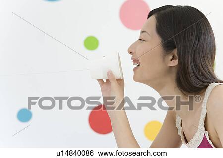 Stock Photograph - Young Woman Using a String Telephone, Smiling, Side View. Fotosearch