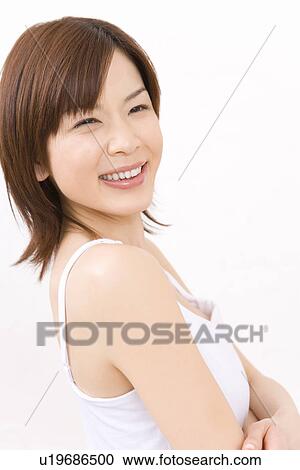 Stock Image - A Smiling Young Woman, Crossing Her Arms, Side View. Fotosearch
