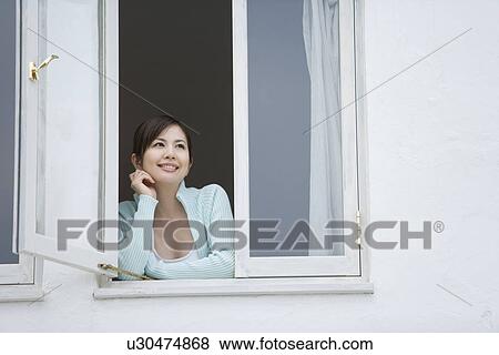 A Smiling Young Woman Looking Outside the Window, Low Angle View View Large Photo Image Stock Photo - A Smiling Young Woman Looking Outside the Window, Low Angle View. Fotosearch