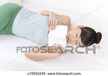 A Young Woman Falling in Asleep While Reading a Book, High Angle View View Large Photo Image Stock Photo - A Young Woman Falling in Asleep While Reading a Book, High Angle View. Fotosearch