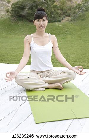 Stock Photograph - A Young Woman Practicing Yoga, Front View. Fotosearch