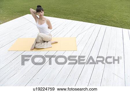 Stock Photo - A Young Woman Practicing Yoga, High Angle View, Front View. Fotosearch