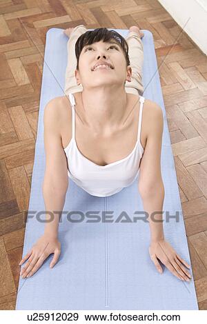 A Young Woman Practicing Yoga, Laying on Her Stomach, High Angle View, Front View View Large Photo Image Stock Photo - A Young Woman Practicing Yoga, Laying on Her Stomach, High Angle View, Front View. Fotosearch