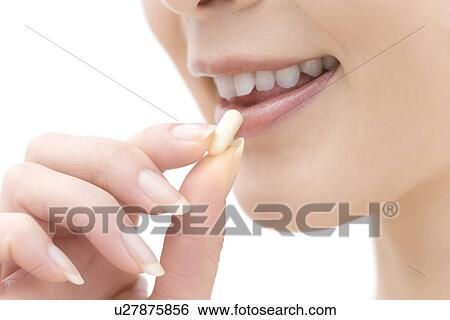 Stock Photograph - A Young Woman Taking a Pill, Side View, Close Up. Fotosearch