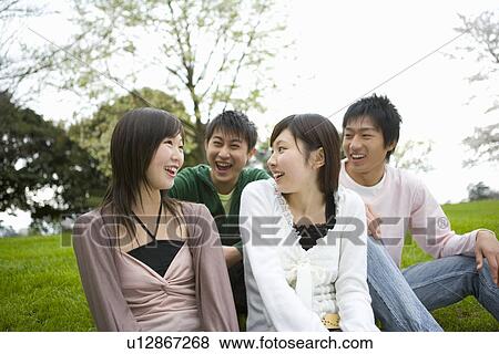 Four young people talking and sitting on lawn, front view, Japan View Large Photo Image Stock Photo - Four young people talking and sitting on lawn, front view, Japan. Fotosearch