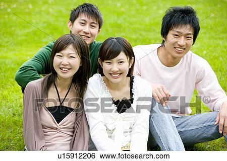 Portrait of four young people sitting on lawn, smiling and looking at camera, front view, Japan View Large Photo Image Stock Photograph - Portrait of four young people sitting on lawn, smiling and looking at camera, front view, Japan. Fotosearch